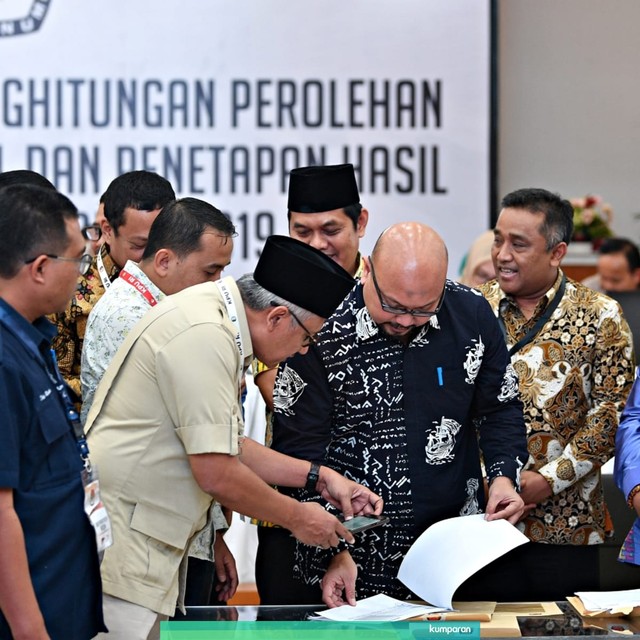 Komisioner KPU Ilham Saputra beserta sejumlah saksi memeriksa berkas hasil rekapitulasi Provinsi Bali. Foto: Antara/Sigid Kurniawan