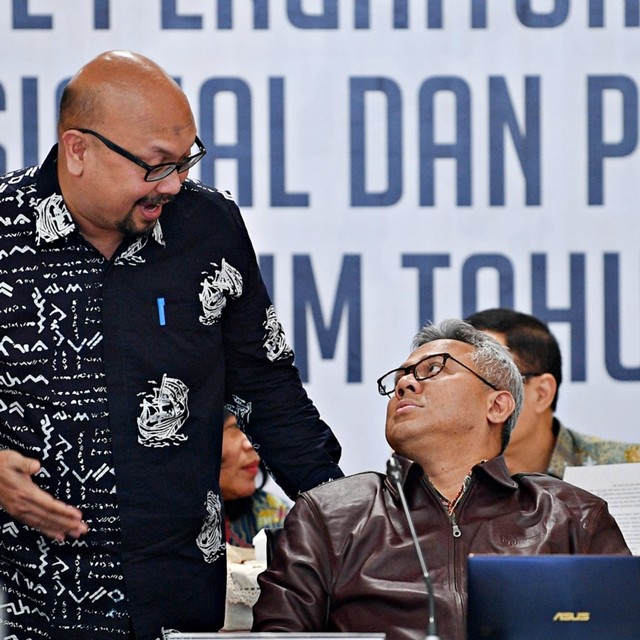 Ketua KPU Arief Budiman berbincang dengan Komisioner KPU Ilham Saputra disela memimpin Rapat Pleno Rekapitulasi Hasil Penghitungan dan Perolehan Suara. Foto: Antara/Sigid Kurniawan