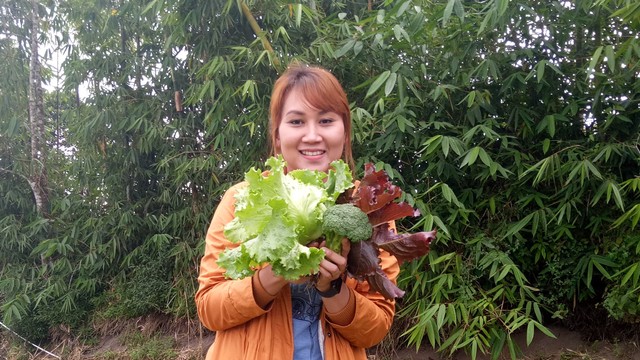 Ratna Sari Dewi bersama sayur mayur hasil kebunnya (kanalbali/LSU)