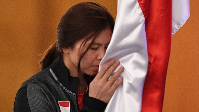 Pebulu tangkis putri Indonesia Greysia Polii mencium bendera Merah Putih saat prosesi pelepasan Tim Piala Sudirman 2019. Foto: Antara/Sigid Kurniawan
