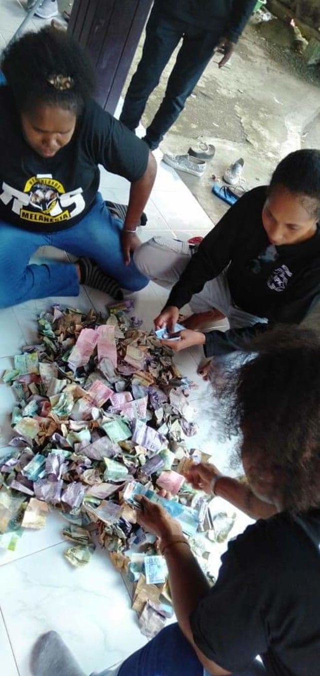 KPK Manokwari menghitung uang hasil penggalangan di beberapa lokasi di Manokwari. Foto:Roli/balleo-kumparan