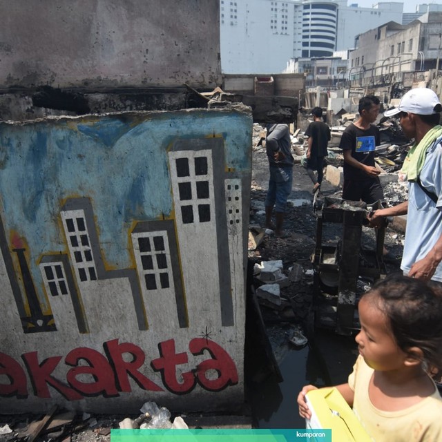 Warga menyelamatkan barang-barang miliknya pascakebakaran yang melanda permukiman padat penduduk di Kampung Bandan, Jakarta Utara, Minggu (12/5). Foto: ANTARA FOTO/Indrianto Eko Suwarso