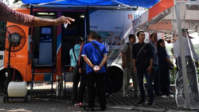 Warga mengantre untuk melakukan penukaran uang di mobil kas keliling bank di Lapangan IRTI Monas, Jakarta, Senin (13/5). Foto: ANTARA FOTO/Sigid Kurniawan