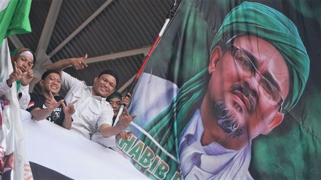 Sejumlah massa kampanye akbar Prabowo-Sandi mengibarkan bendera dengan gambar Habib Rizieq Shihab di Stadion Gelora Bung Karno. Foto: Irfan Adi Saputra/kumparan