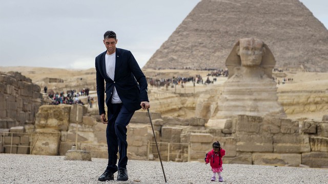 Wanita terpendek di dunia asal India, Jyoti Amge (kanan) berfoto bersama pria tertinggi di dunia asal Turki Sultan Kosen di lokasi Piramida Giza, Mesir. Foto: AFP