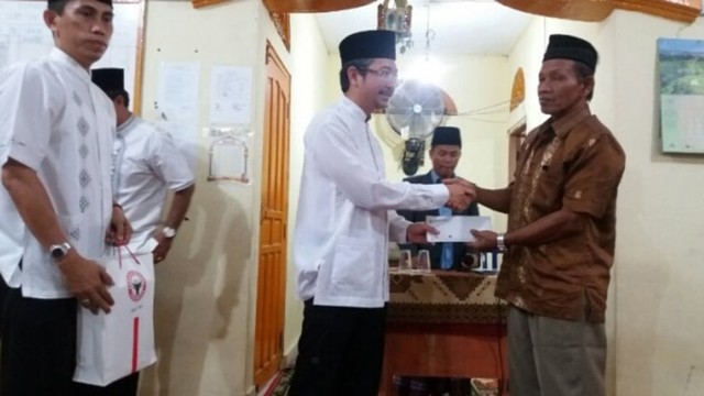 Direktur Keuangan PT Semen Padang Tri Hartono Rianto menyerahkan bantuan saat kegiatan safari Ramadan Semen Padang. (Dokumen Semen Padang)