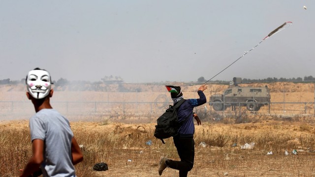 Dua orang demonstran melakukan protes di garis perbatasan Israel-Palestina saat memperingati ke 71 tahun hari Nakba. Foto: AFP
