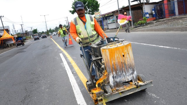 Pekerja mengecat marka jalan di Jalan Lintas Sumatera (Jalinsum) Tanjung Morawa, Kabupaten Deliserdang, Sumatera Utara. Foto: ANTARA FOTO/Septianda Perdana