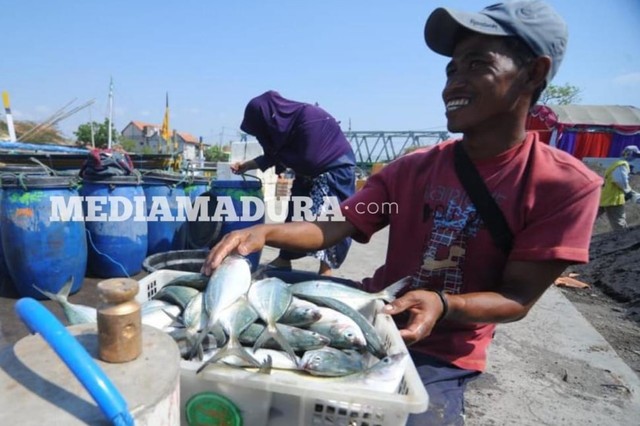 Nelayan asal Sampang menurunkan hasil tangkapan ikan di pelabuhan tanglok, Jumat (12/10/2018). (Ryan Hariyanto/MM).