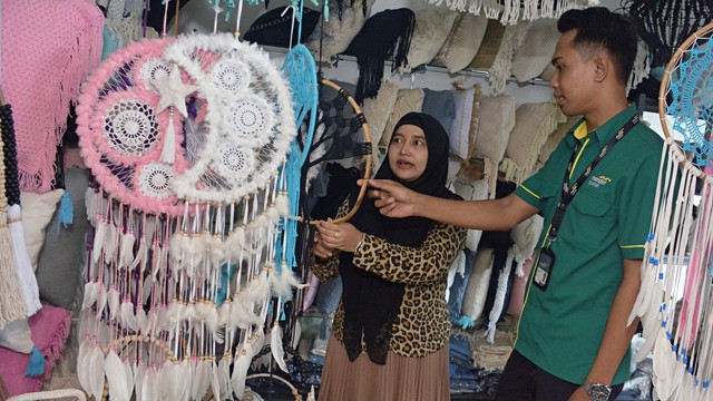 Pegawai Mandiri Syariah berbincang dengan nasabah Usaha Kecil dan Menengah (UKM) kerajinan tangan khas Bali. Foto: Antara/Fikri Yusuf