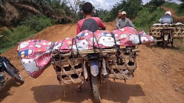 Jenazah Jojok (45) dibawa menggunakan sepeda motor menuju rumahnya di Desa Alim, Kecamatan Batang Cenaku, Kabupaten Indragiri Hulu (Inhu), Riau, Kamis, 16 Mei 2019. (Foto: Facebook/OM Dory)