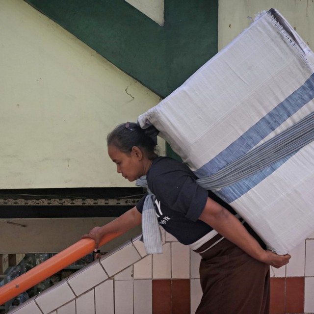 Buruh gendong saat menuruni tangga membawa beban. Foto: Fanny Kusumawardhani/kumparan