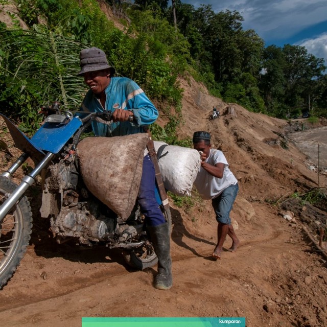 Warga mebantu mendorong sepeda motor yang melintasi tebing gunung akibat jalan utama Trans Palu-Kulawi terputus diterjang banjir di Desa Salua, Kecamatan Gumbasa, Sigi, Sulawesi Tengah, Minggu (19/5). Foto: ANTARA FOTO/Basri Marzuki