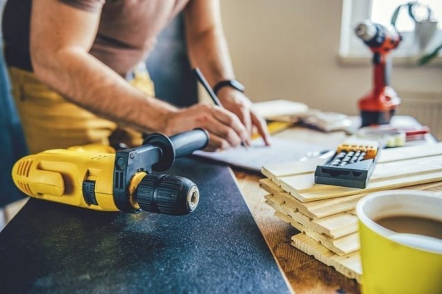 bikin rancangan untuk reparasi rumah dengan perkakas dan tumpukan kayu