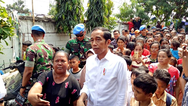 Presiden Jokowi berjalan bersama warga ketika tiba di Kampung Deret. Foto: Kevin S Kurnianto/kumparan