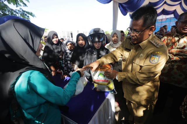 Wali Kota Banda Aceh menyerahkan paket kepada warga di pasar murah Ulee Kareng. Foto: Humas Banda Aceh 