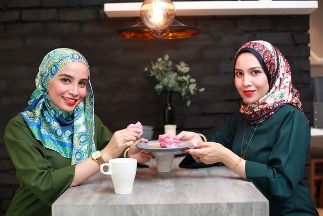 com-Ilustrasi dua wanita berhijab sedang menikmati makanan Foto: Shutterstock