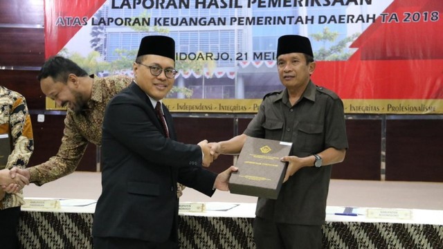 Wakil Bupati Bojonegoro Drs Budi Irawanto, saat menerima penghargaan dari Kepala Perwakilan BPK Provinsi Jawa Timur, Harry Purwaka. Selasa ((21/05/2019)