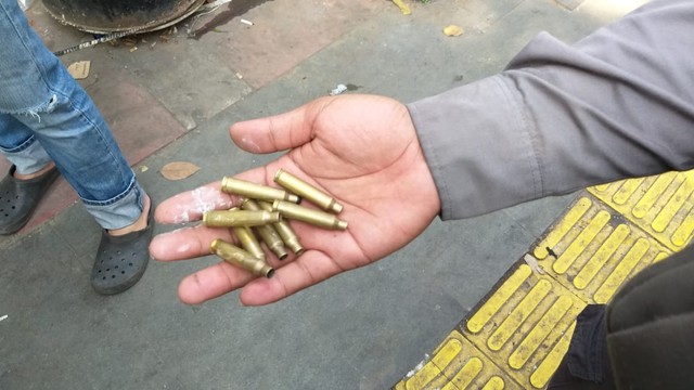 Seorang warga memperlihatkan selongsong peluru, Aksi Massa