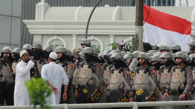 Perwakilan warga berbincang dengan anggota kepolisian saat adanya kerumunan massa di atas jalan layang Slipi Jaya. Foto: Antara/Muhammad Iqbal