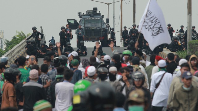 Anggota Brimob memblokade massa yang berkumpul di atas jalan layang Slipi Jaya. Foto: Antara/Muhammad Iqbal