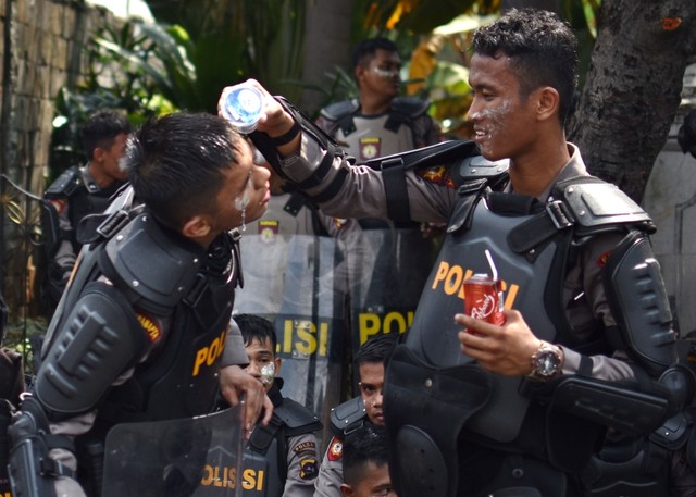 Seorang polisi mengguyur air pada muka rekannya karena terdampak gas air mata saat kerusuhan terjadi di di Jalan KS Tubun. Foto: Antara/Aditya Pradana Putra
