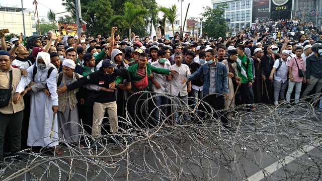 Kelompok massa saat menenangkan massa lainnya saat berunjuk rasa di depan Kantor Bawaslu Sumut. Foto: Rahmat Utomo/kumparan