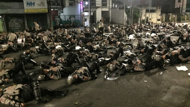 Sejumlah anggota kepolisian tidur di Jalan Brigjen Katamso. Foto: Fachrul Irwinsyah/kumparan