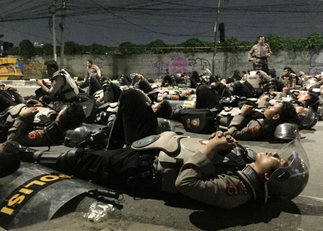 Sejumlah anggota kepolisian tidur di Jalan Brigjen Katamso. Foto: Fachrul Irwinsyah/kumparan