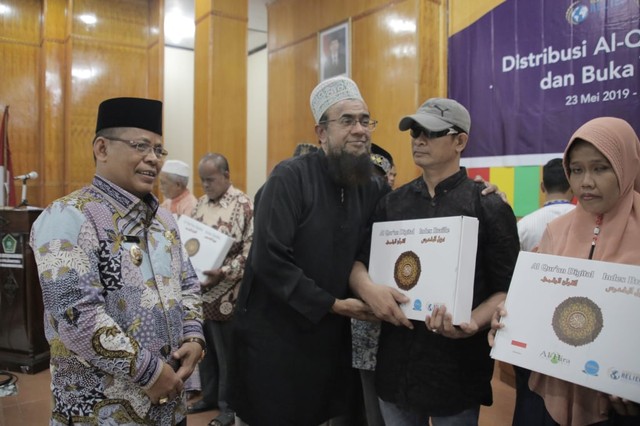CEO Global Ehsan Relief Singapura, Basheer Ahmad, ditemani Wali Kota Banda Aceh Aminullah Usman, menyerahkan Alquran braille digital kepada tunanetra di Asrama Haji Embarkasi Aceh, Banda Aceh, Kamis (23/5). Foto: Dok. GER