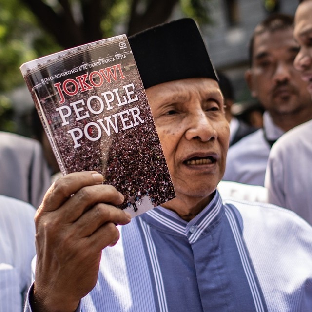 Amien Rais menunjukkan buku berjudul Jokowi People Power. Foto: ANTARA FOTO/Aprillio Akbar