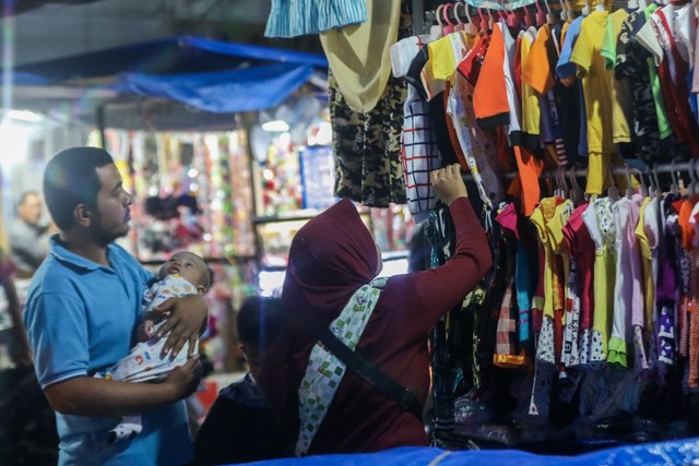 Seorang ibu memilih pakaian untuk anaknya di Pasar Atjeh, Banda Aceh. Foto: Suparta/acehkini