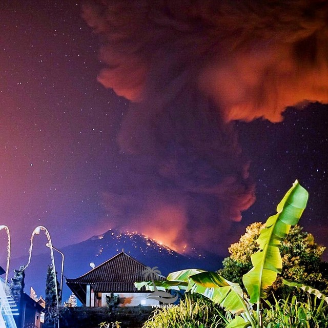 Asap tebal dan cahaya dari guguran lava terlihat ketika Gunung Agung mengeluarkan erupsi di Kabupaten Karangasem, Bali. Foto: Wayan Kartika/via REUTERS