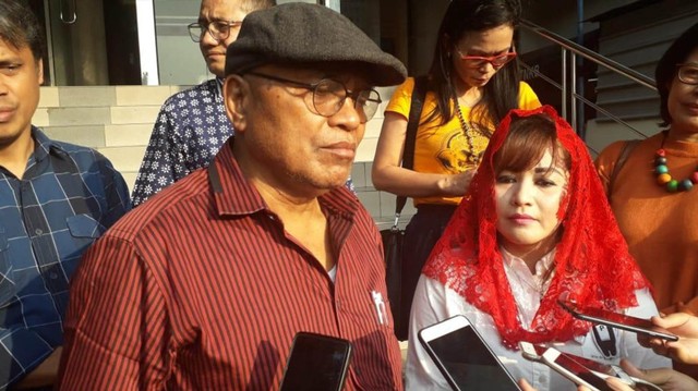 Petrus Selestinus (bertopi) dan Dewi Tanjung di SPKT Polda Metro. Foto: Andreas Ricky Febrian/kumparan