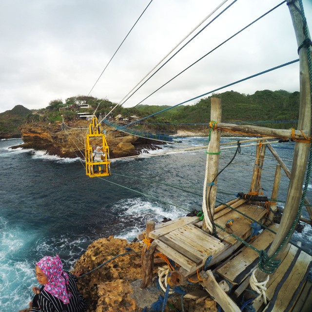 Seorang pengunjung sedang menaiki gondola di Pantai Timang, Gunungkidul, Yogyakarta. Foto: Aria Sankhyaadi/kumparan