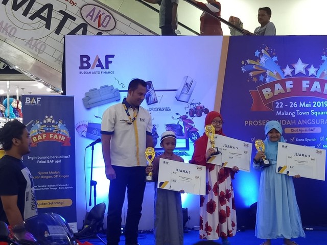 Area Marketing Manager Dana Syariah BAF Indonesia untuk area Jawa Timur, Bali, NTB, NTT, Herry Eko Prasetyo (kiri) foto bersama dengan para pemenang lomba mewarnai di BAF Fair, di Malang Town Square, 26 Mei lalu.