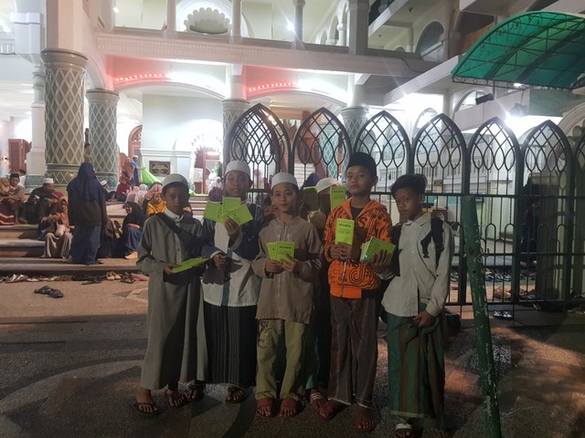 Anak-anak yang menjual doa witir di depan Masjid Jami Agung Kota Malang, Senin malam (28/5).(foto: Irham Thoriq/Tugu Malang).