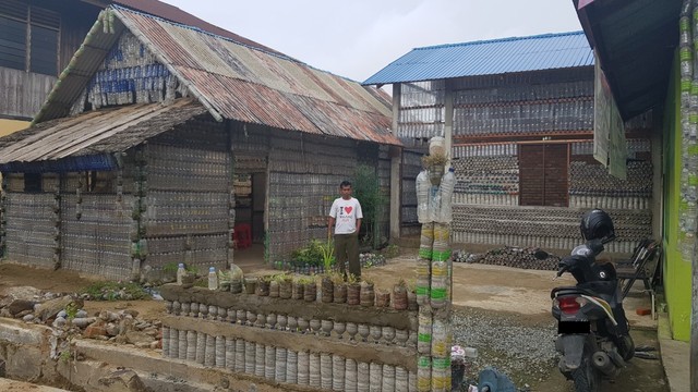 Dennis Kelen Laba berfoto di depan bangunan rumah botol yang diperuntukkan menjadi kampung Inggris | Photo by Charles (Karja.id)