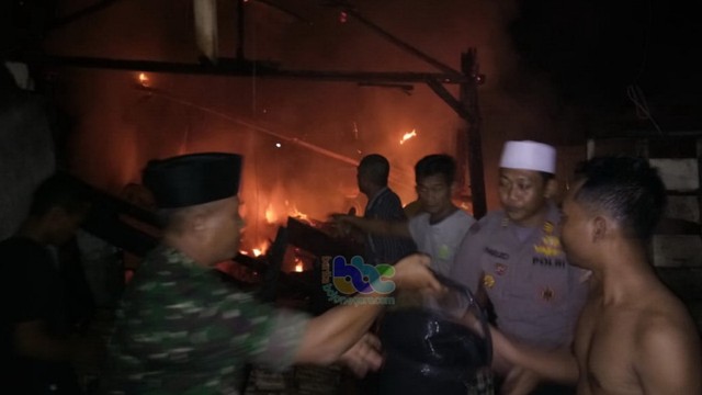 Aparat bersama warga saat berupaya memadamkan kebakaran rumah milik Moh Uzaini (58), warga Kecamatan Gayam Bojonegoro. Rabu (29/05/2019)