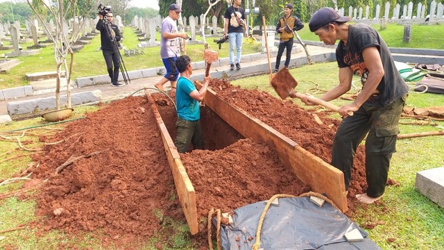 Sejumlah petugas menggali kubur di TMP Kalibata. Foto: Fadjar Hadi/kumparan