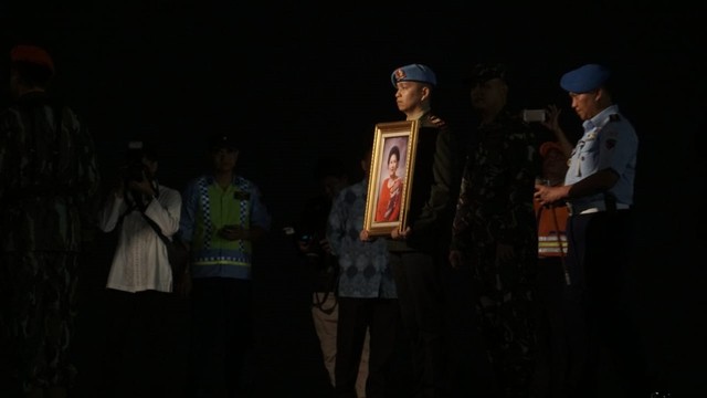 Seorang anggota TNI membawa foto jenazah Ani Yudhoyono di Bandara Halim Perdana Kusuma. Foto: Irfan Adi Saputra/kumparan