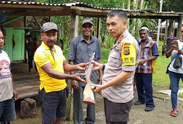 Saat Kapolres Kepulauan Yapen, AKBP Penri Erison terima senpi rakitan dari warga di Kampung Ransamoni. (Foto Humas Polda Papua)