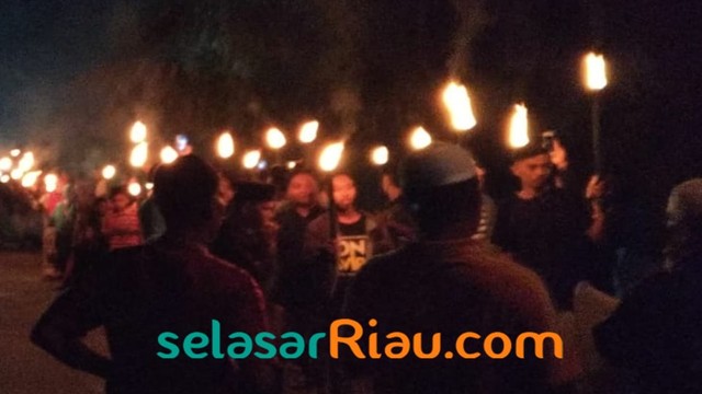 WARGA saar mengikuti pawai obor sekaligus pencak silat, Selasa malam, 4 Juni 2019, di Desa Alam Panjang, Rumbio Jaya, Kabupaten Kampar, Riau.  