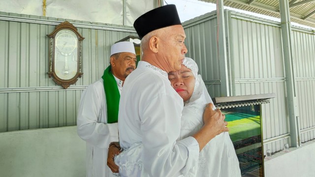 Ritman berpelukan dengan keluarganya usai salat Id, dan mengenang hilangnya sembilan anggota keluarganya di lokasi likuefaksi Balaroa saat bencana melanda Kota Palu pada 28 September 2019 lalu. Foto: Ikram/Palu Poso