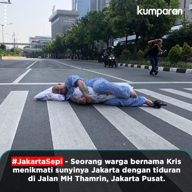 Seorang warga bernama Kris menikmati sunyinya Jakarta dengan tiduran di Jalan MH Thamrin, Jakarta Pusat. Foto: Paulina Herasmarindar dan Sabryna Muviola/kumparan