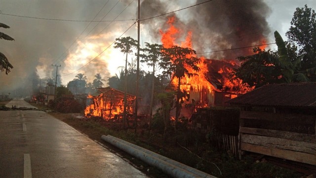 Puluhan rumah masih dalam kondisi terbakar di Desa Gunung Jaya usai terjadi keributan antar pemuda di perbatasan antara Desa Gunung Jaya dan Desa Sampuabalo, Buton, Sulawesi Tenggara, Rabu (5/6). Foto: ANTARA FOTO/ Emil