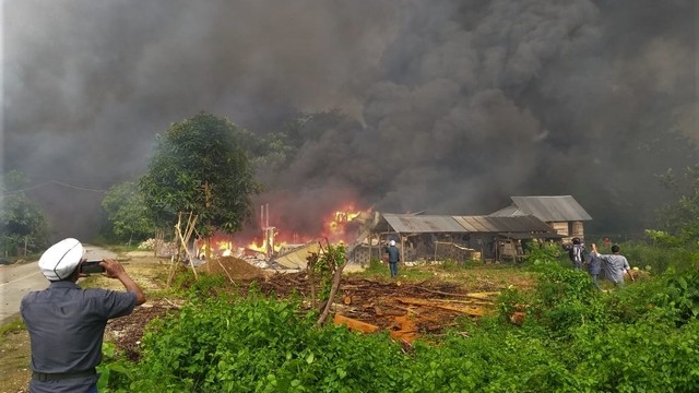 Kepulan asap hitam dari puluhan rumah yang dibakar di Desa Gunung Jaya usai terjadi keributan antar pemuda di perbatasan antara Desa Gunung Jaya dan Desa Sampuabalo, Buton, Sulawesi Tenggara, Rabu (5/6). Foto: ANTARA FOTO/ Emil