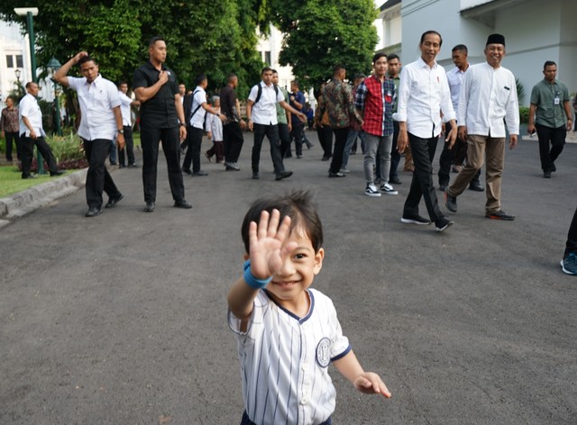 cucu Presiden RI Joko Widodo melambaikan tangan ke arah fotografer saat ia bersama Presiden Joko Widodo dan Walikota Yogyakarta Haryadi Suyuti (kedua kanan) mengunjungi Gedung Agung Yogyakarta, Kamis (6/6). Foto: ANTARA FOTO/Andreas Fitri Atmoko