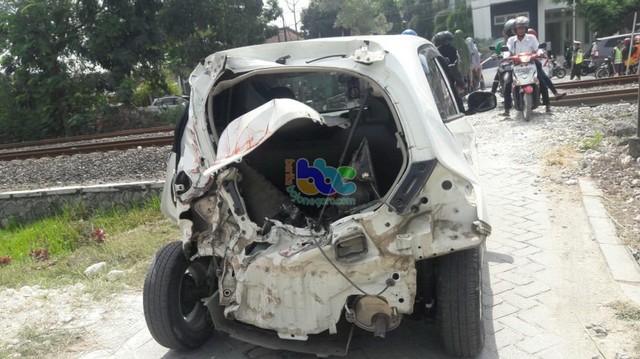 Mobil Honda Brio warna putih nomor polisi S 1559 AN, yang tertabrak kereta api di perlintasan tanpa palang pintu turut wilayah Desa Plesungan Kecamatan Kapas Bojonegoro. Jumat (07/06/2019).