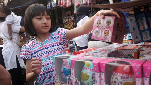Seorang anak sedang memilah mainan di Pasar Gembrong, Jakarta Timur. Foto: Iqbal Firdaus/kumparan